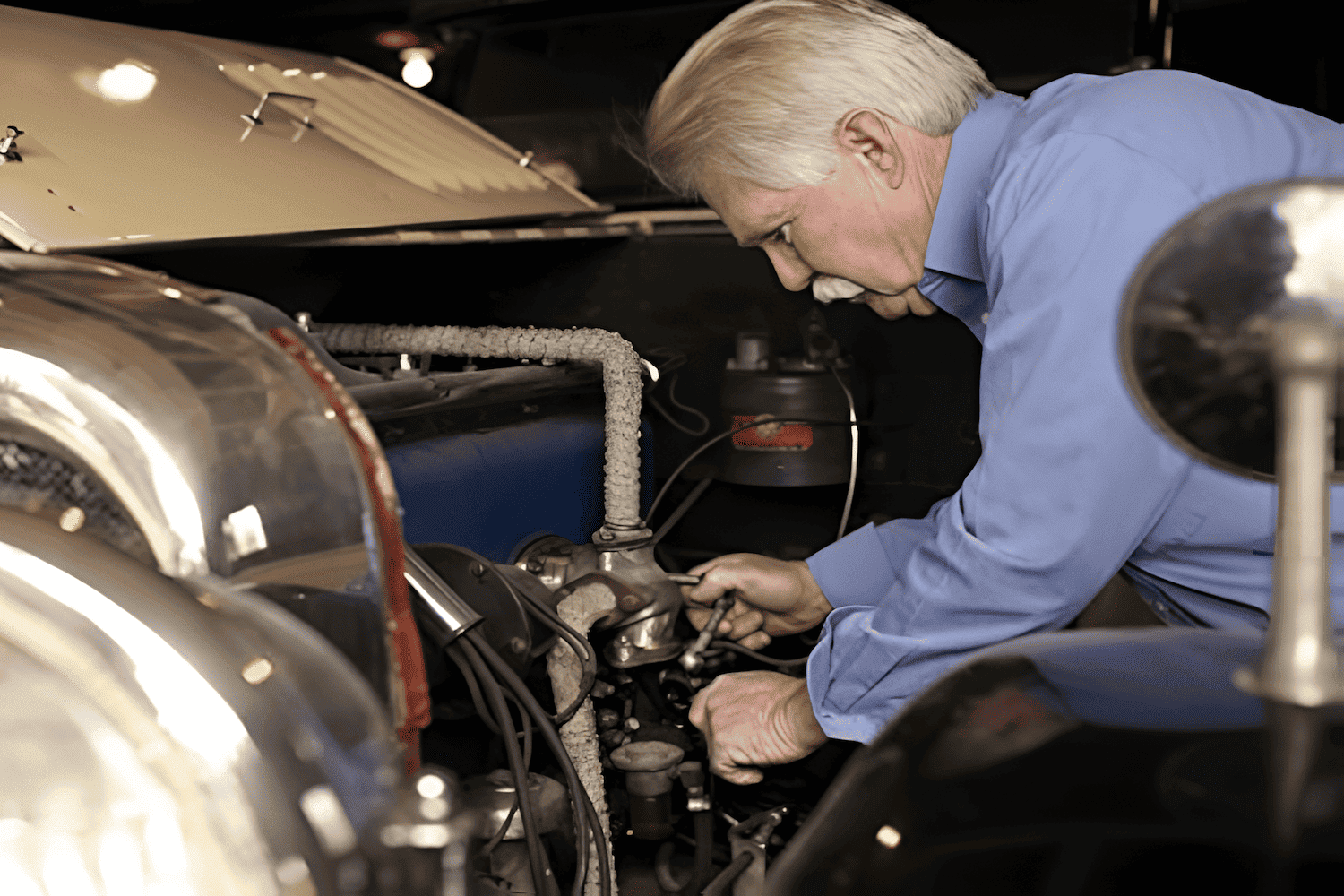 older man working on a vintage car